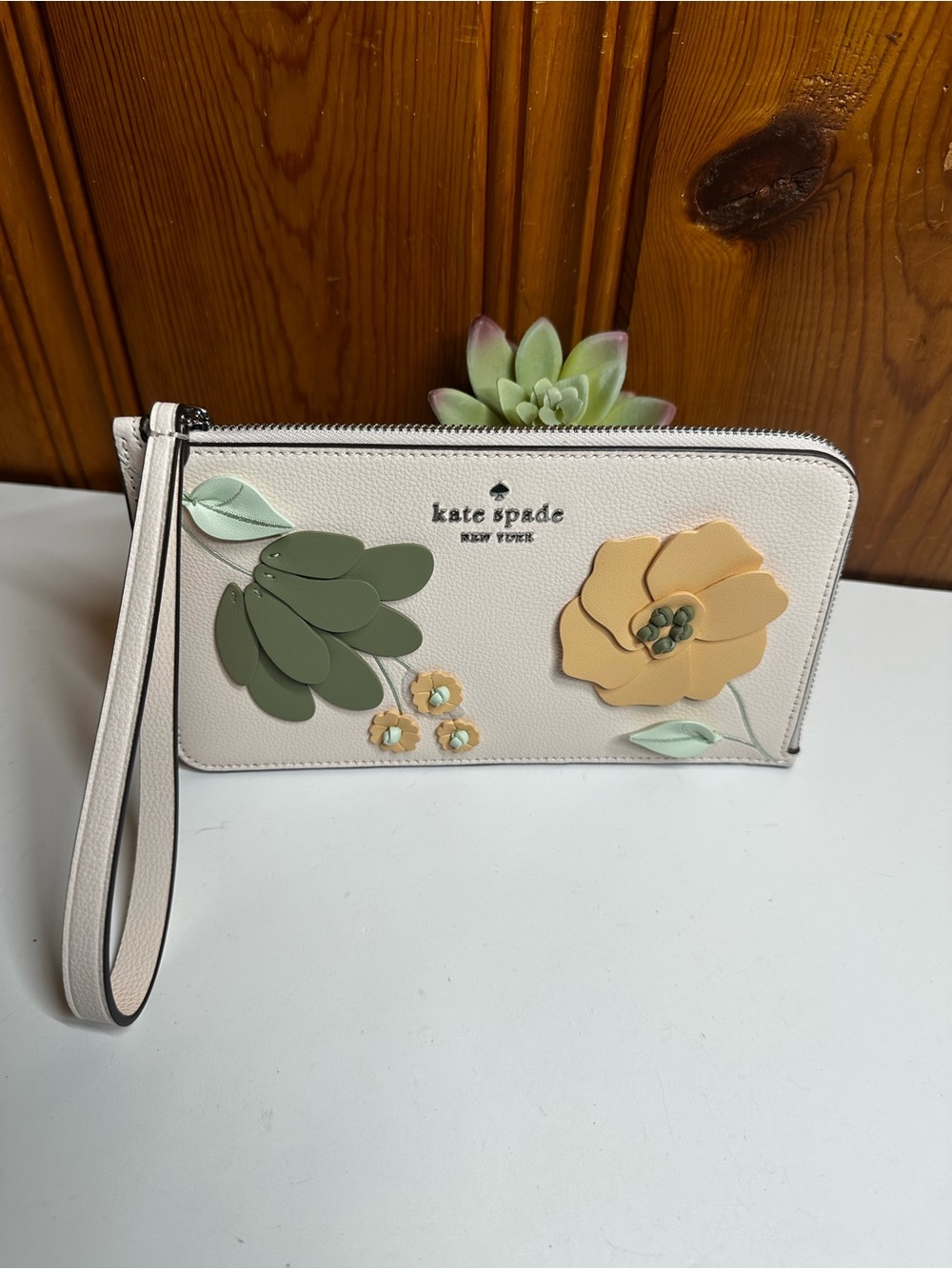kate spade cream floral appliquรฉ wristlet with green and yellow accents